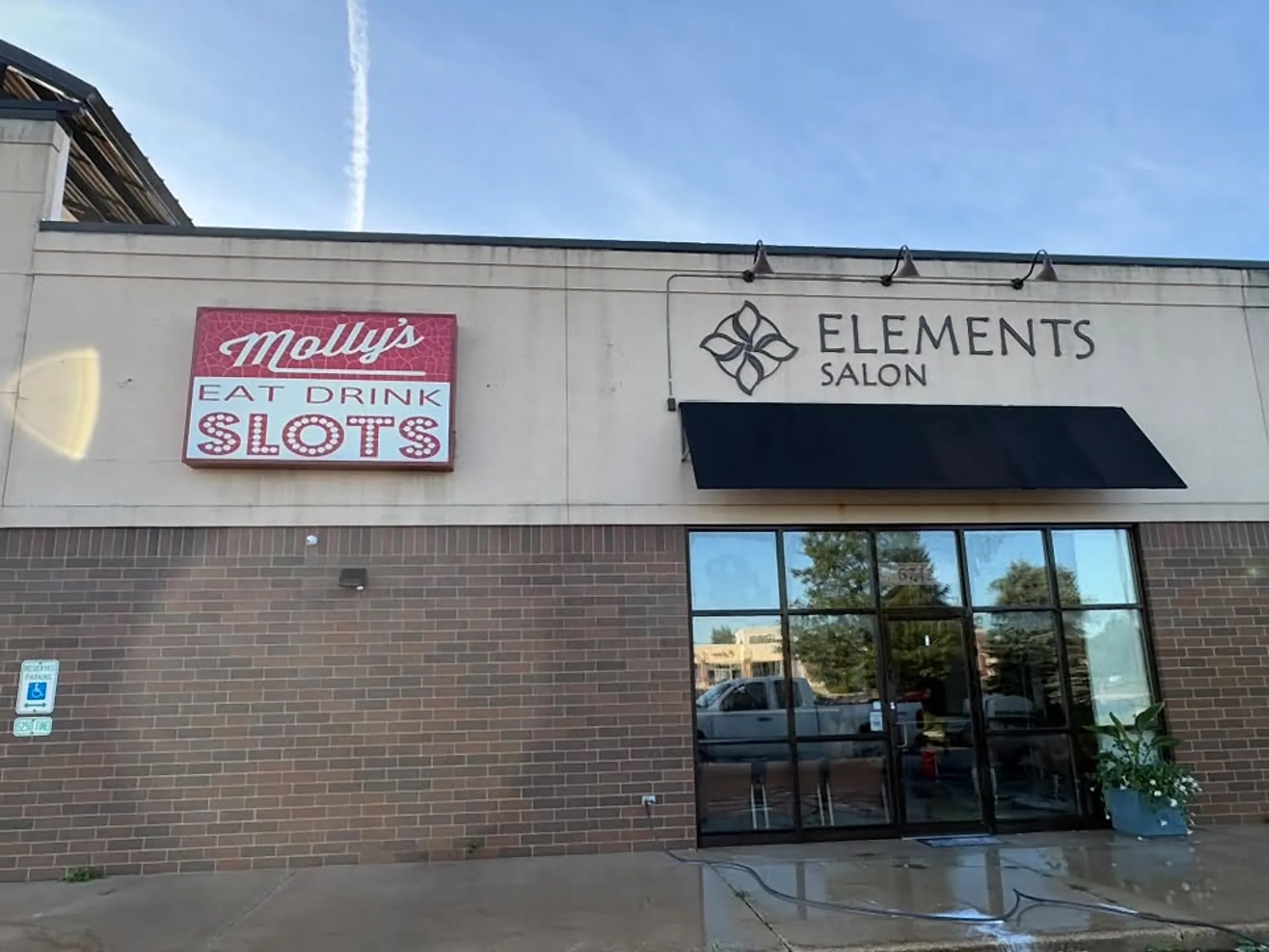 Salon and bar frontage with freshly cleaned brick and wet sidewalk