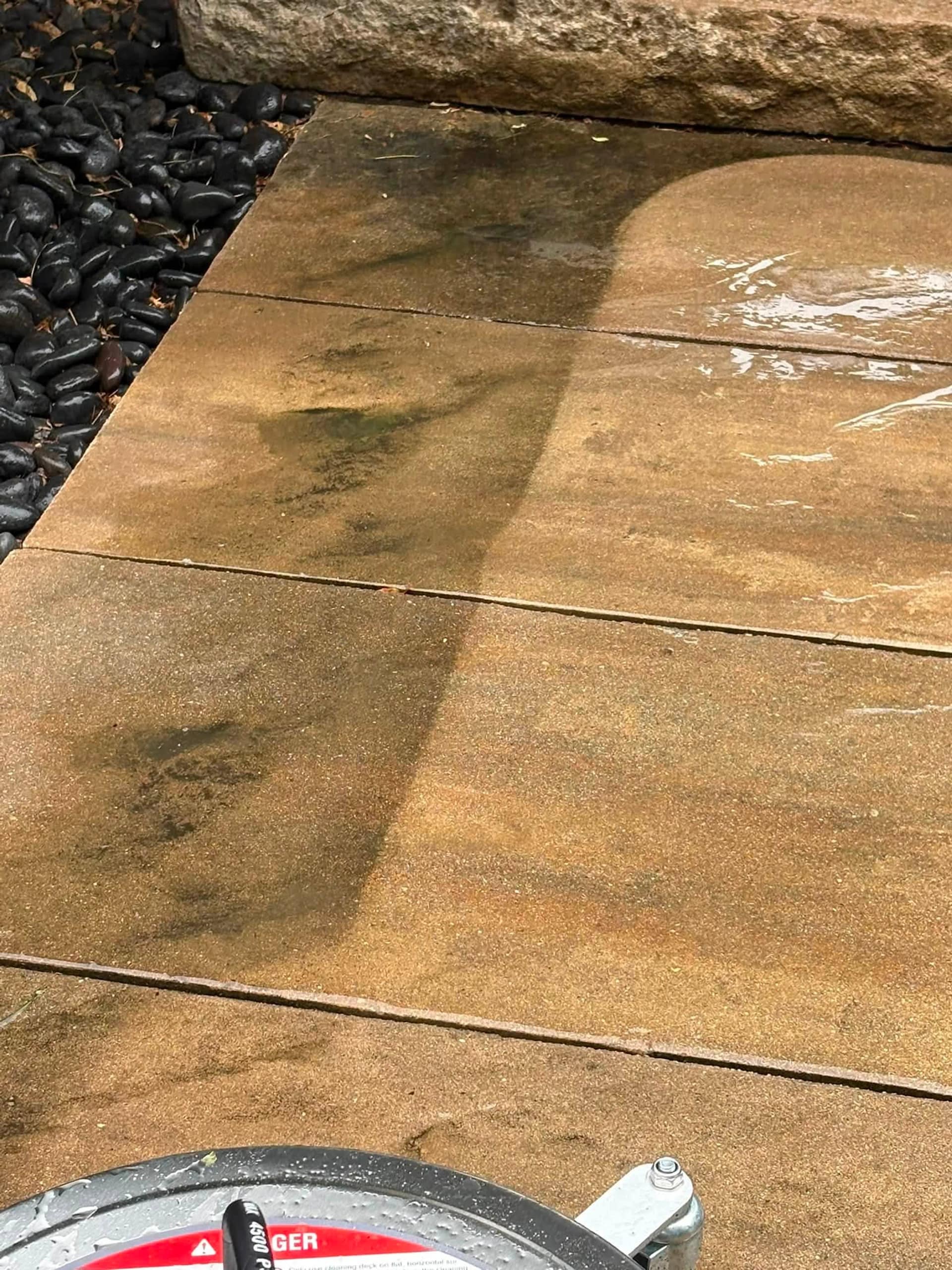 Rust and soil staining lifting off a concrete pad, the surface cleaner still resting on the slab