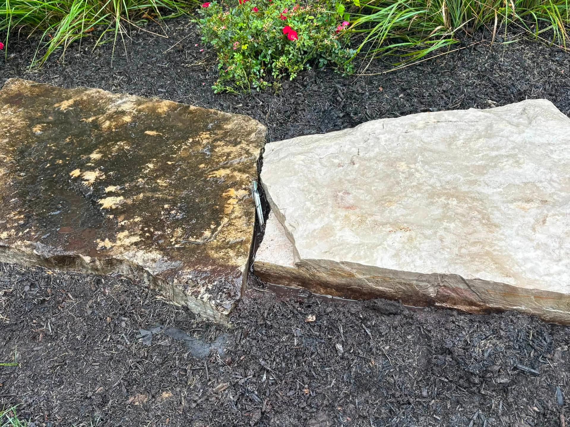 A stone cap half cleaned, soil staining on one slab and bright limestone on the next